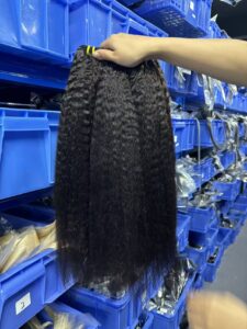 Three bundles of 100% virgin yaki straight weave held in warehouse showing natural yaki texture