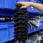 Bulk virgin deep wave human hair bundles close up view, uniform spiral curls natural black unprocessed virgin hair
